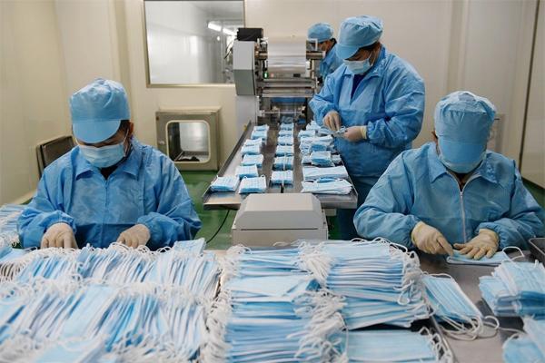 3月10日,在江西康藍醫療器械,工人們正在口罩生產線上忙. .